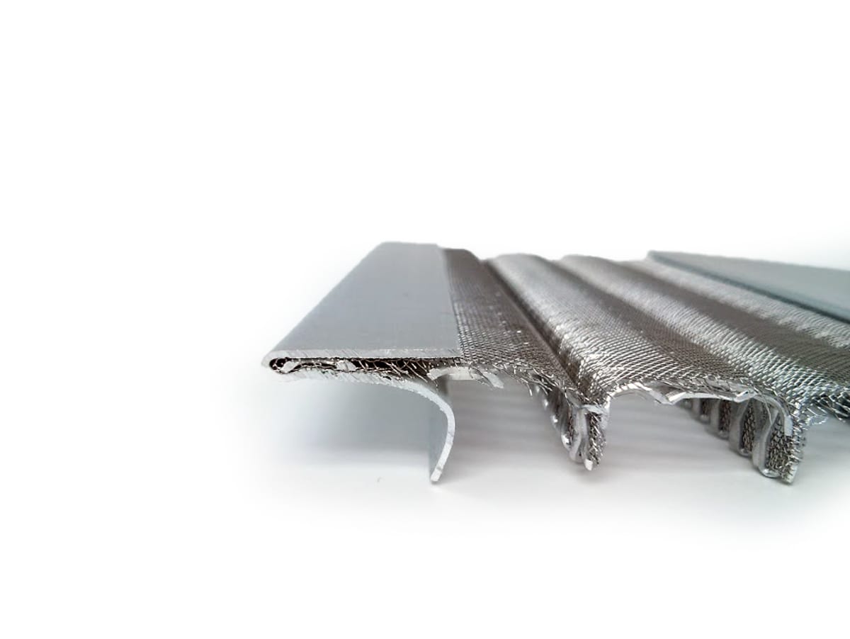 Edge-on view of a Leaf Solution guard showing the hemmed aluminum frame and raised mesh channels